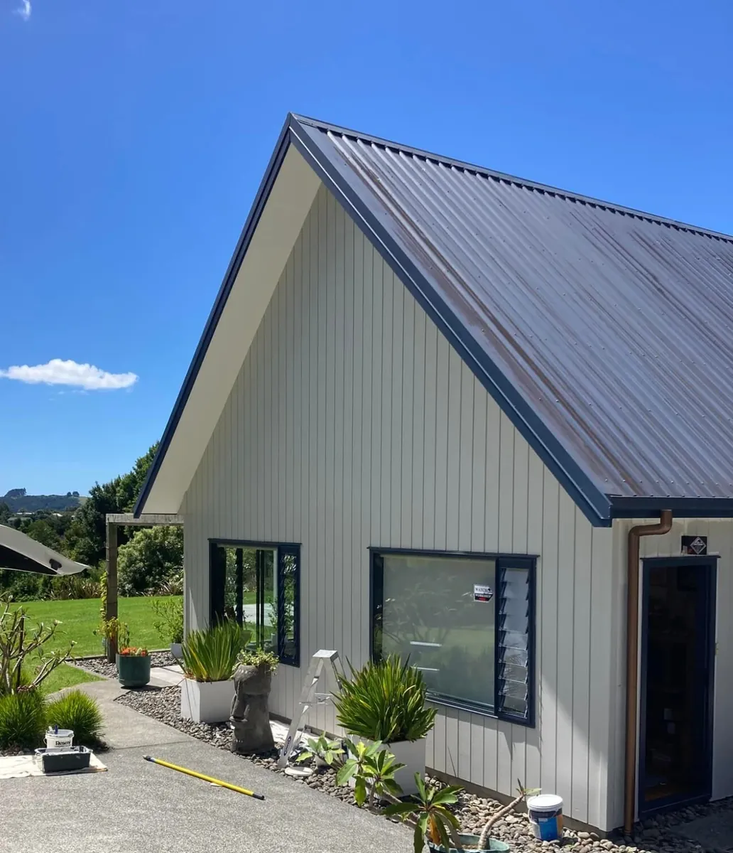 After: the same house repainted in crisp white with dark trim