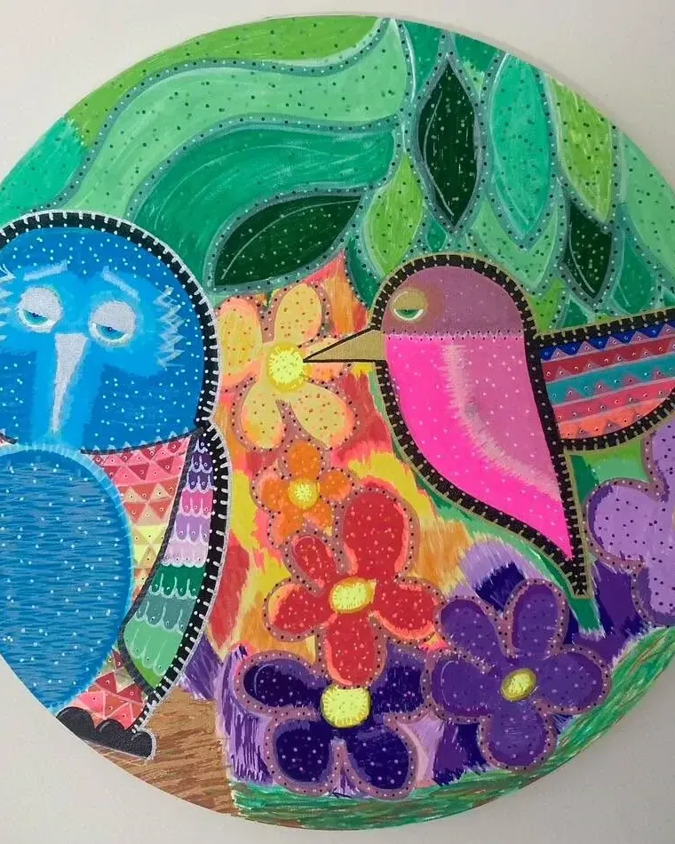Hand-painted round artwork of two colourful birds among flowers